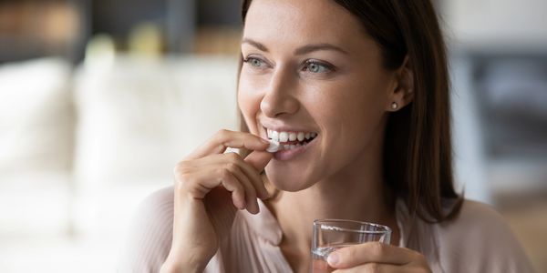 Lady taking a tablet of powders although we do not do tablets as we are totally flexible 
