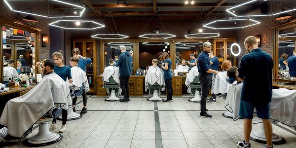Barbers cutting hair in a modern barbershop.