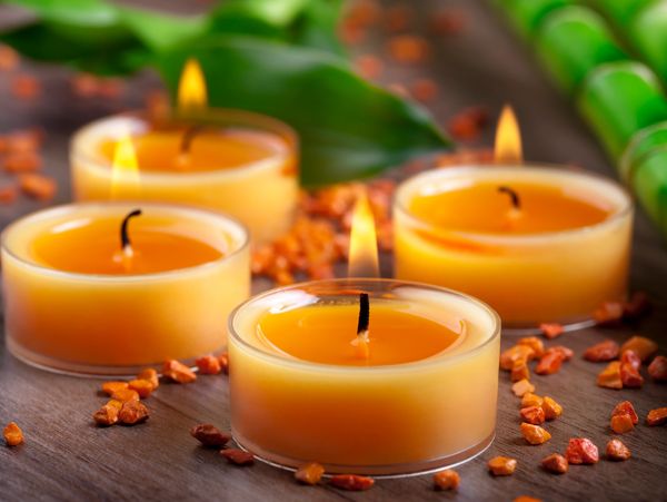 Lit candles with orange stones.