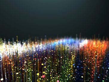 Colorful glowing fiber optic strands creating a vibrant wave pattern.
