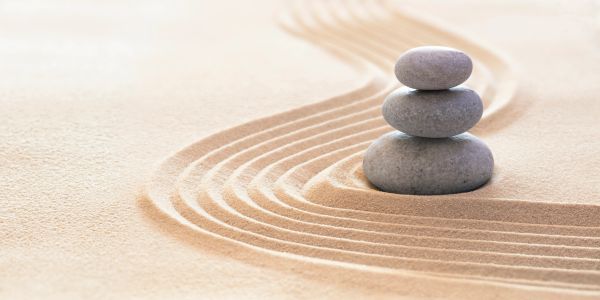 Minimalist Japon bahçe tasarımı, üst üste dizilmiş taşlar ve kum çizgileri.