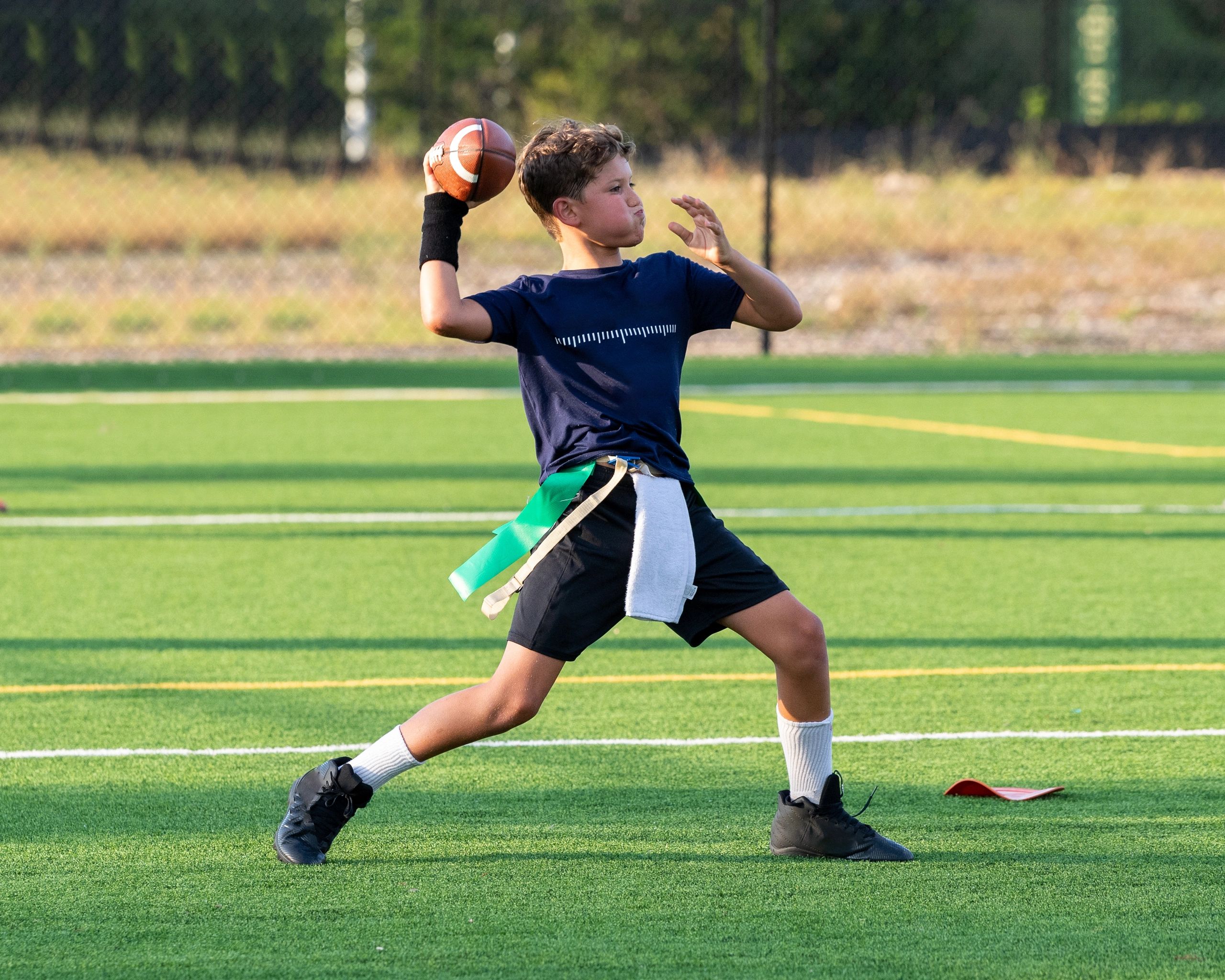 Young boy preparing to throw a football on a sports field.