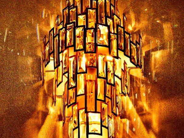 A glowing golden chandelier with rectangular glass panels.