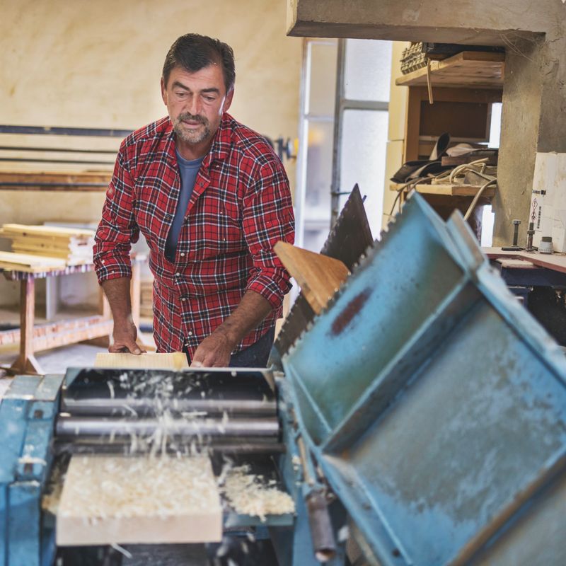 Production manager overseeing woodworking operations in workshop
