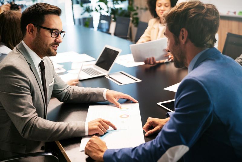 Image of business partners discussing documents and ideas at meeting