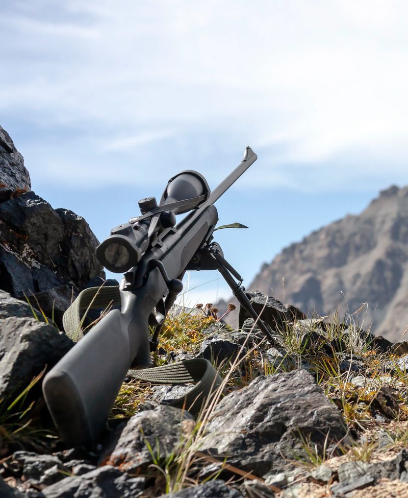 Hunting rifle with optical sight on bipods prepared for hunting in the mountains. Sniper weapons in the mountains before shooting.