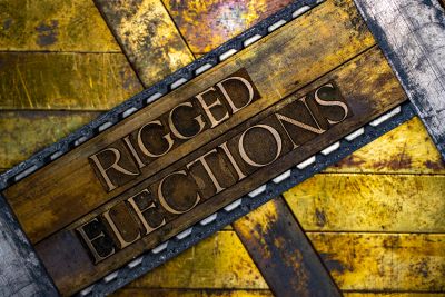 Wooden sign reading 'Rigged Elections'.
