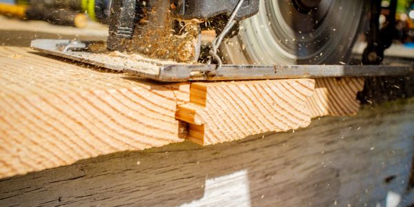 Circular saw cutting through wood, creating sawdust.