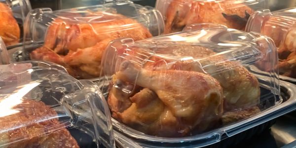 Whole roasted chickens in plastic containers.