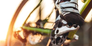 Close-up of a cyclist's shoe clipped into a pedal during a sunset ride.