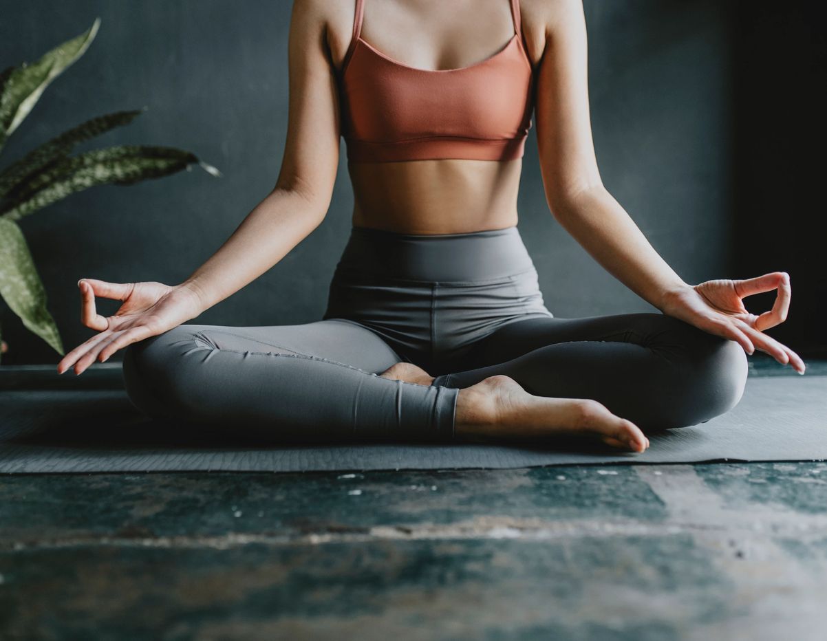 Woman meditating in lotus position indoors.