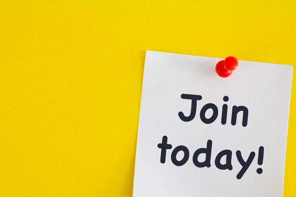 White note pinned on yellow board saying Join today!