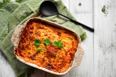 Un plat de lasagnes gratinées avec du persil.
