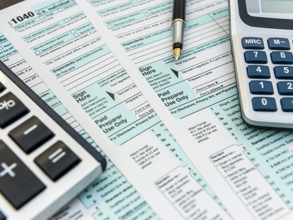 Tax forms with calculators and a pen ready for filling out.