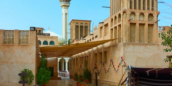 Traditional Middle Eastern architecture with wind towers and a mosque minaret.