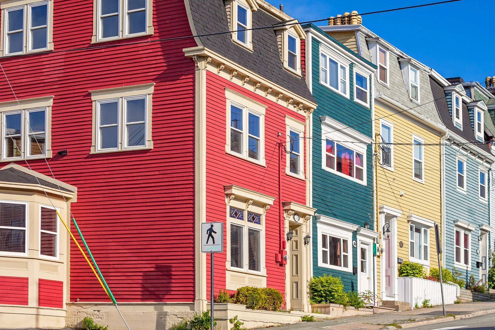 Row of colorful houses on a sunny street with a clear blue sky.