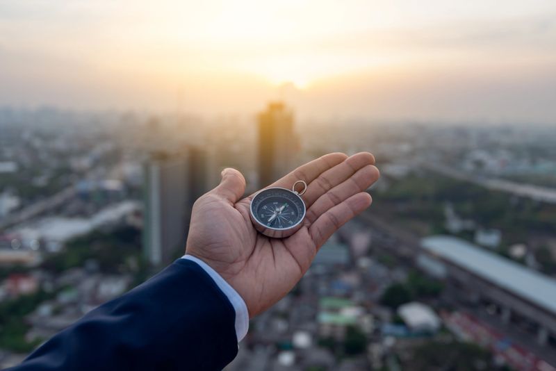 Businessman holding a navigation compass in hand and define marketing direction, Business success concept