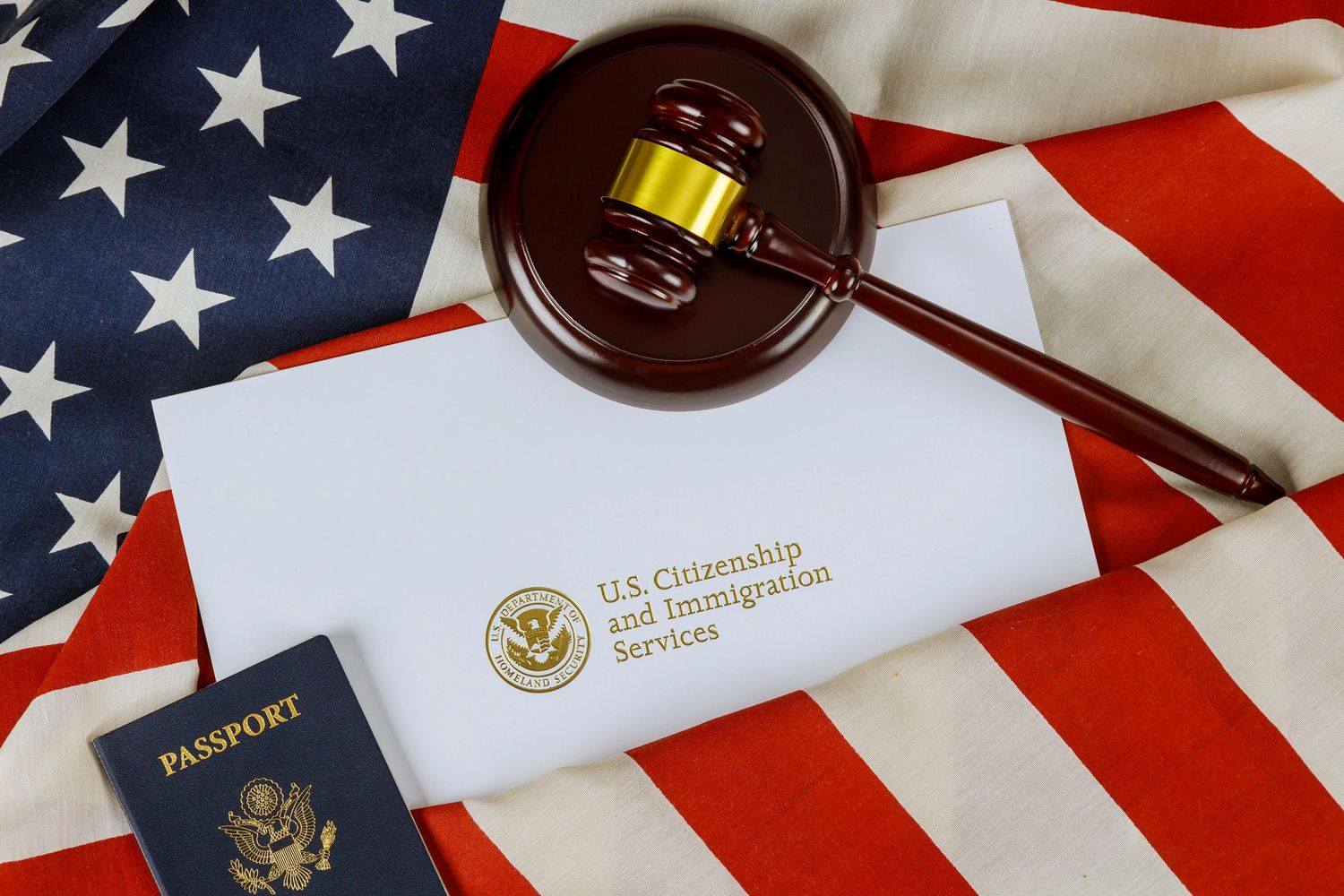 U.S. Citizenship document, passport, and judge's gavel on American flag.