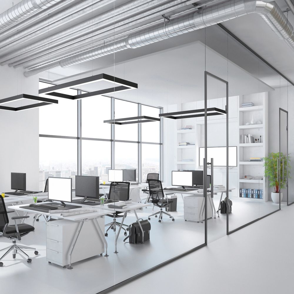 Modern office space with glass walls and sleek desks.