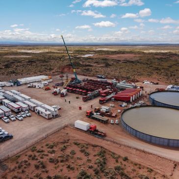 Aerial view of an industrial site with storage tanks and vehicles.