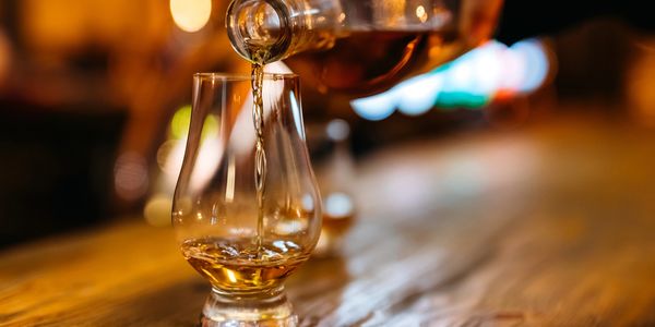 pouring bourbon into a Glencairn glass