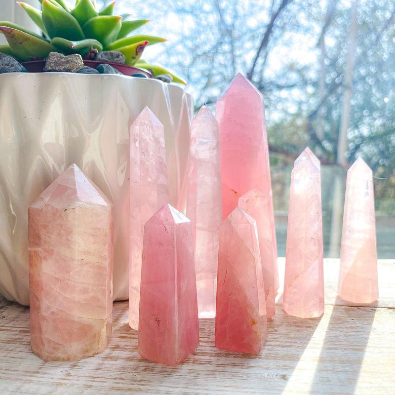 Rose quartz crystals on the window with day light and plants