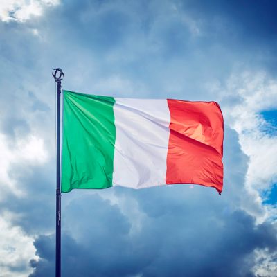 Italian flag waving against a cloudy sky.