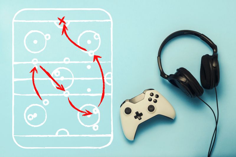 Headphones and gamepad on a blue background. Added drawing with the tactics of the game. Hockey. The concept of computer games, entertainment, gaming, leisure. Flat lay, top view