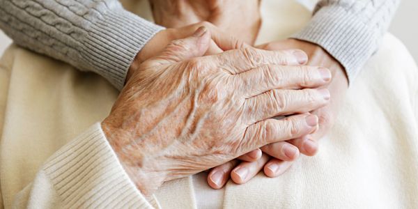 Close-up of elderly hands holding each other.