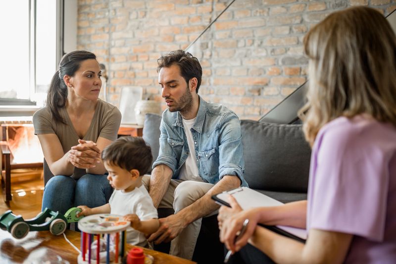 Young couple with a child on a therapy with a therapist. They are in their living room. Belgrade, Serbia