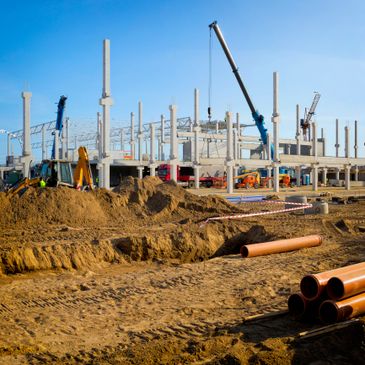 Construction site with cranes and building framework under clear blue sky.