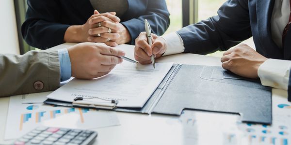 A group of people sitting at a table with papers.