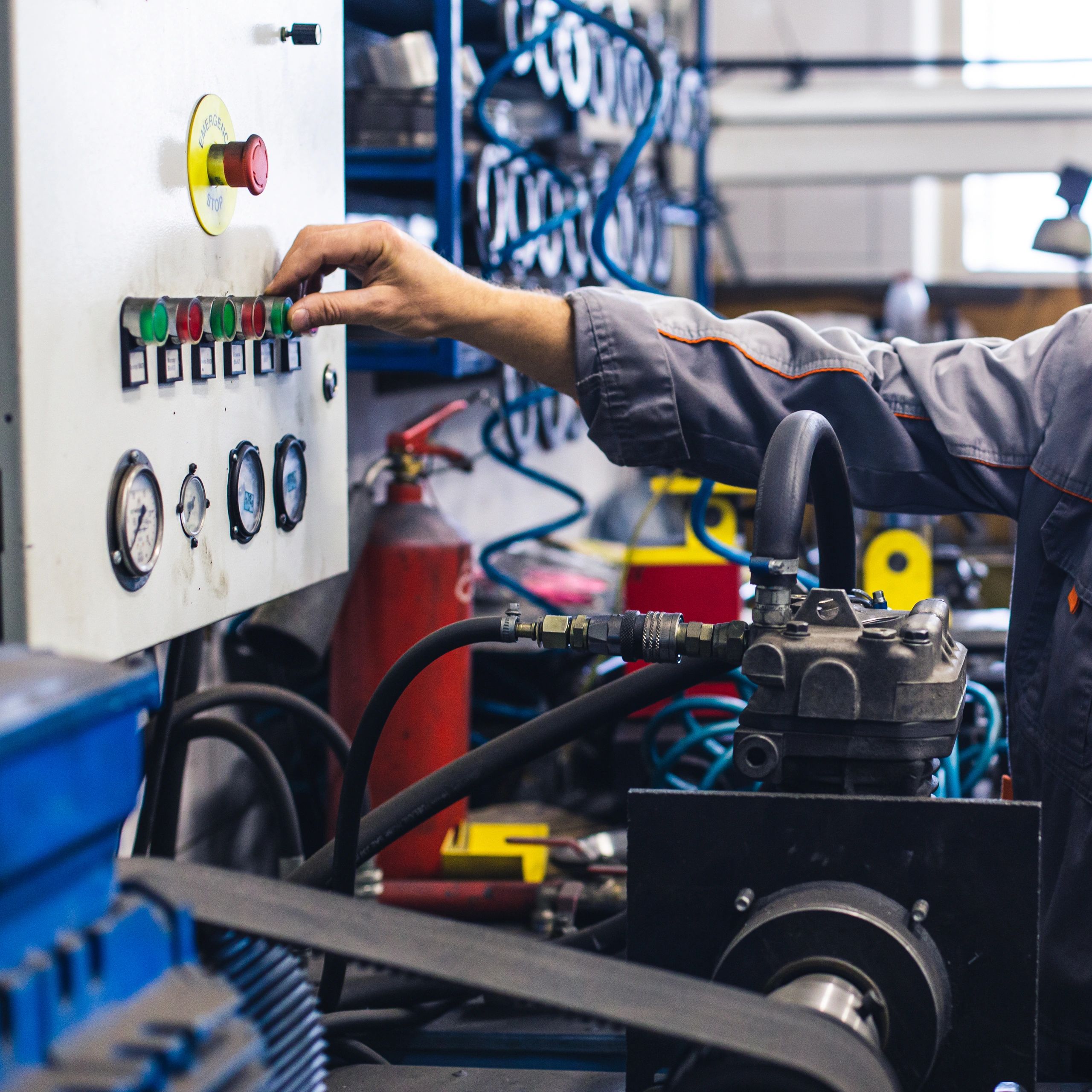 Hand adjusting control panel buttons in an industrial setting.