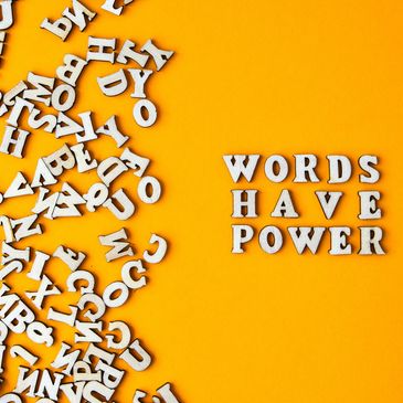 Scattered letters on one side of the image contrast the phrase “Words have power” on the other side.