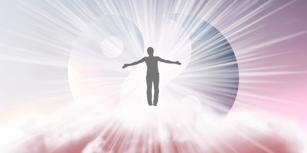 Silhouette of a person standing with arms outstretched in front of a glowing yin-yang symbol.