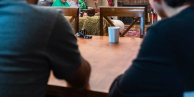 People gathered around a table with a cup.