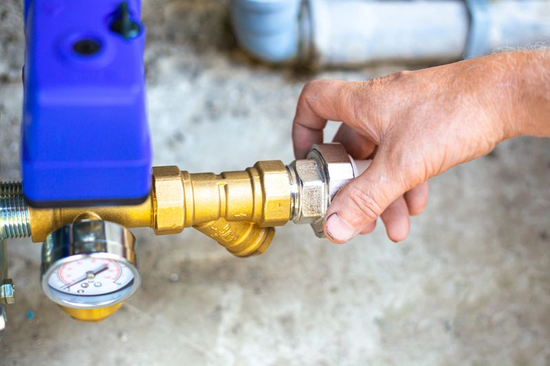 A plumber installs a pumping station to supply water. Residential building water supply.