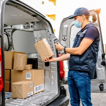 Delivery worker checking packages and tablet.