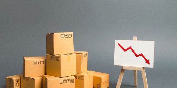 Boxes stacked next to a declining graph on an easel.