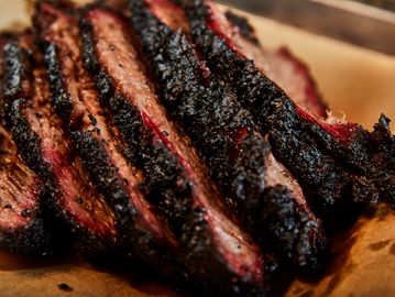 Sliced smoked beef brisket with a dark crust.