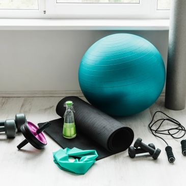 Home workout gear including exercise ball, dumbbells, and yoga mat.