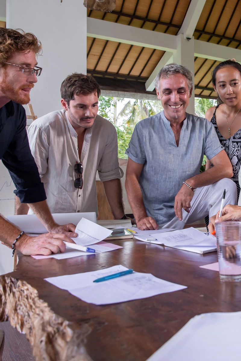 Happy diverse multiethnic business team talking, discussing and brainstorming on project paperwork at meeting, seminar or presentation in birght office