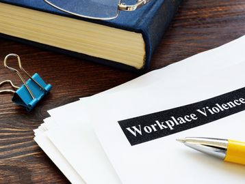 Documents about workplace violence on a desk.