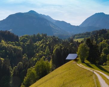 A scenic landscape featuring a mountain range under a clear blue sky.