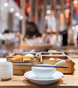 Dim sum and tea set on a wooden table in a restaurant.