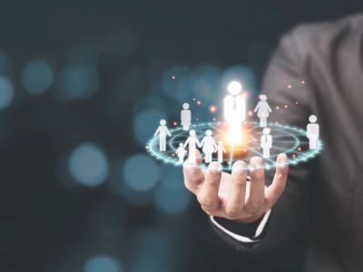 A hand holding a digital hologram of connected people icons.