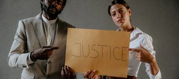 Two people holding a sign that reads 'JUSTICE'.