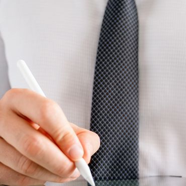 Person in formal attire using a stylus on a tablet.