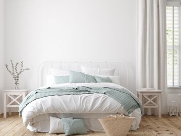 Bright, cozy bedroom with white and pastel blue bedding and natural decor.