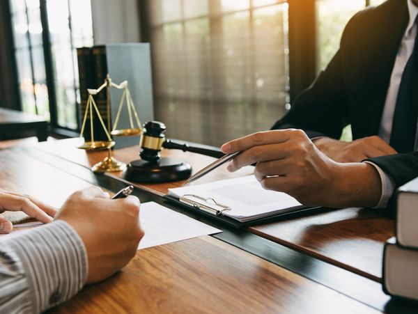 Attorney advising a client and pointing to a contract.